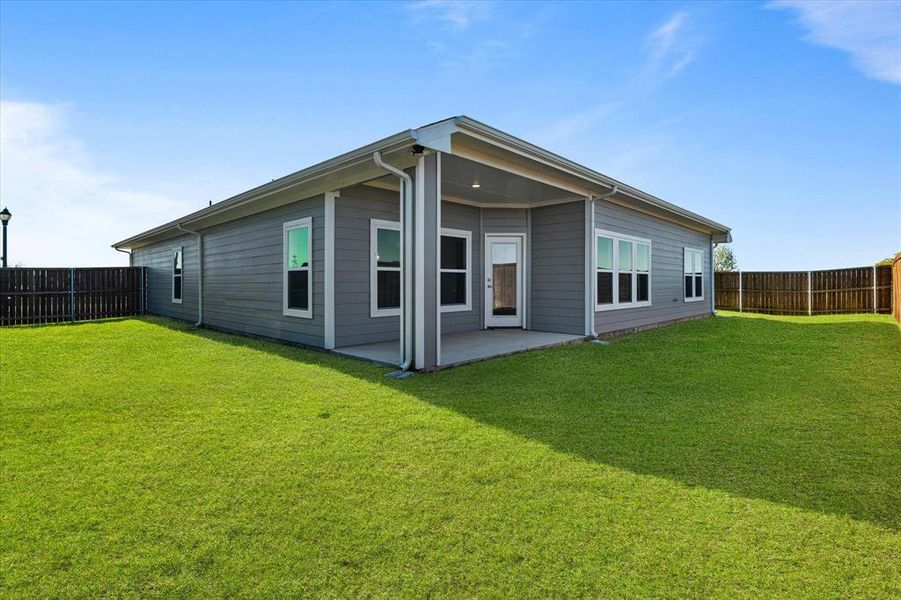 Rear view of house featuring a lawn and a patio area