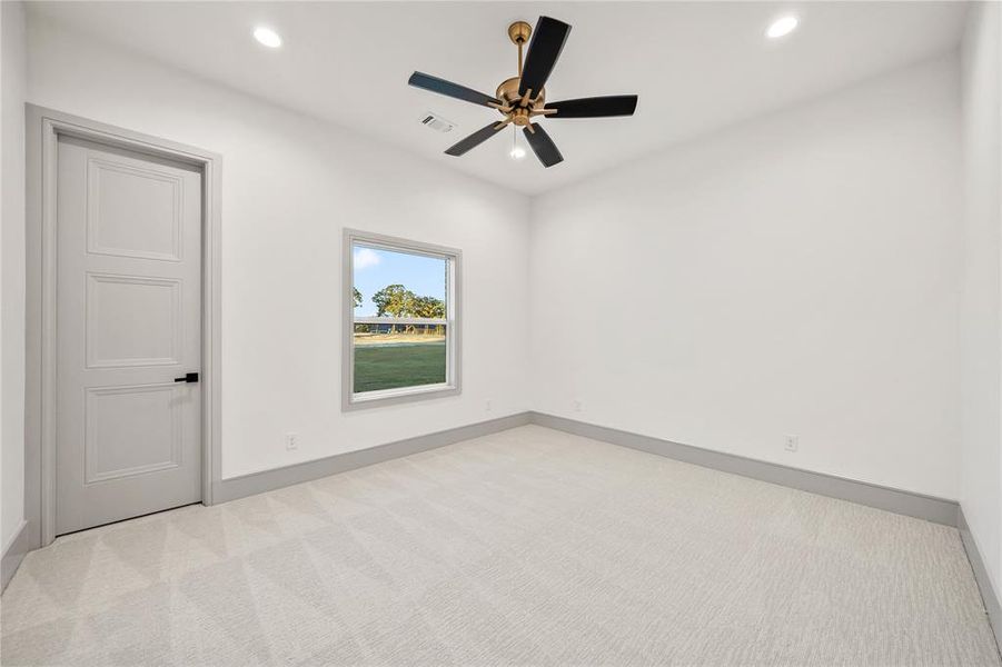 Empty room with light carpet, a ceiling fan, and recessed lighting Empty room with light carpet, a ceiling fan, and recessed lighting