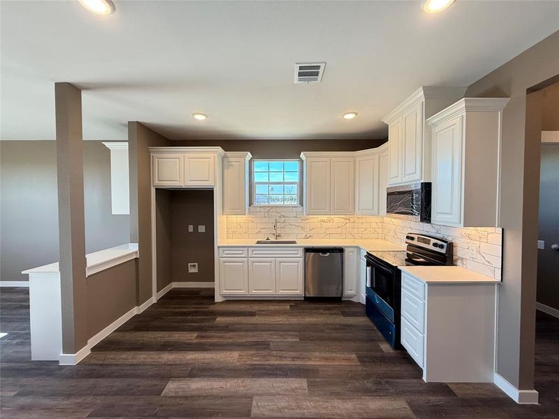 Kitchen featuring white cabinetry, appliances with stainless steel finishes, sink, and decorative backsplash