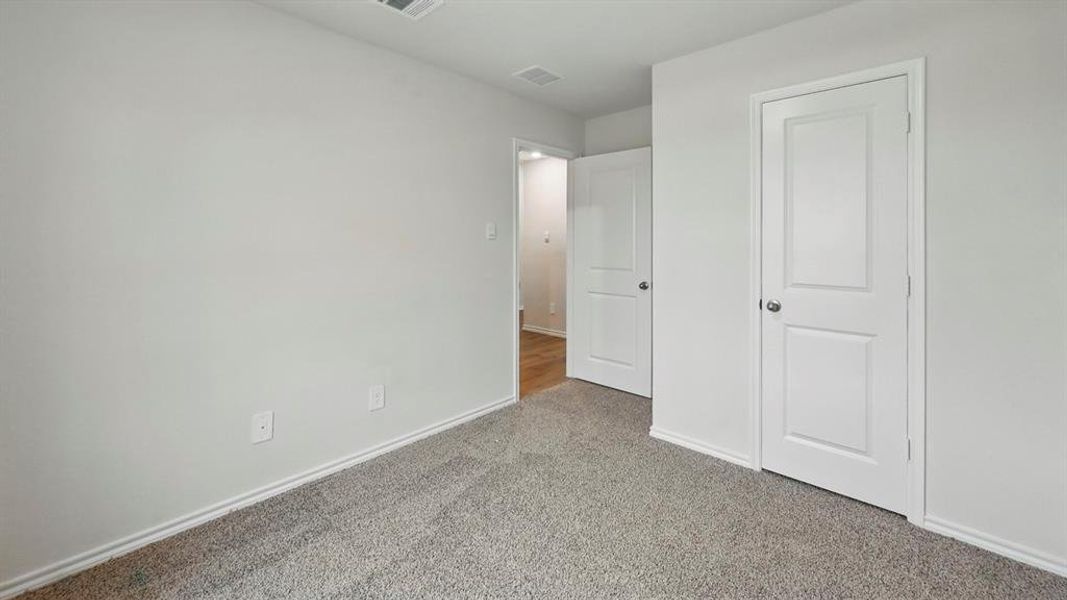 Unfurnished bedroom with carpet flooring and baseboards