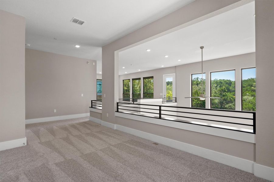 Natural light floods this versatile open-concept living area, featuring a modern chandelier and verdant outdoor views. Natural light floods this versatile open-concept living area, featuring a modern chandelier and verdant outdoor views.