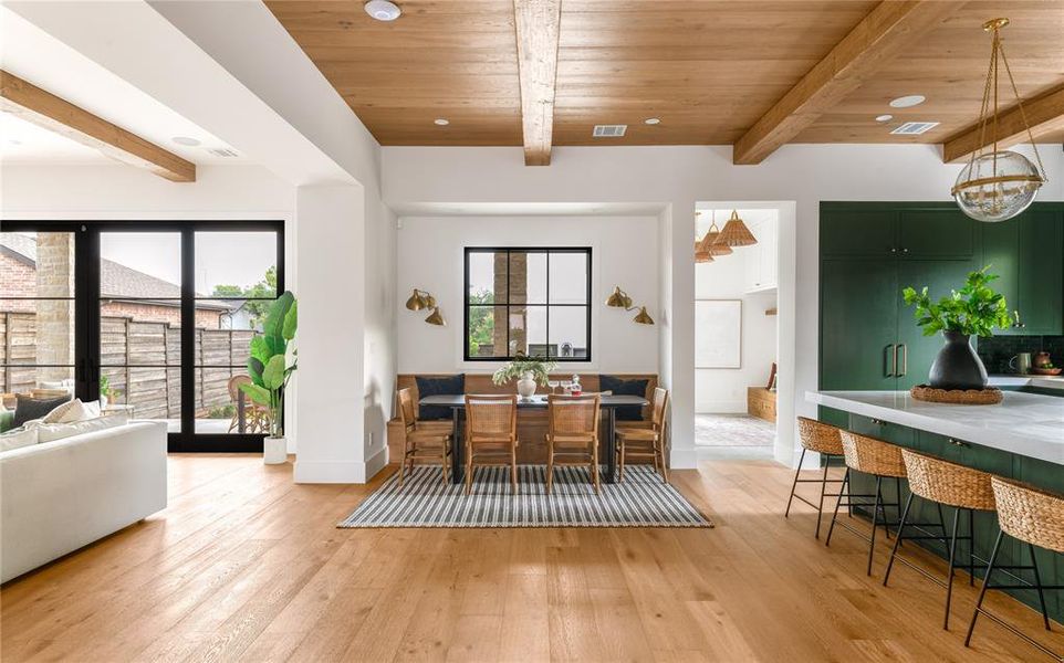 Dining space with light wood-style floors and a wooden ceiling with exposed beams
