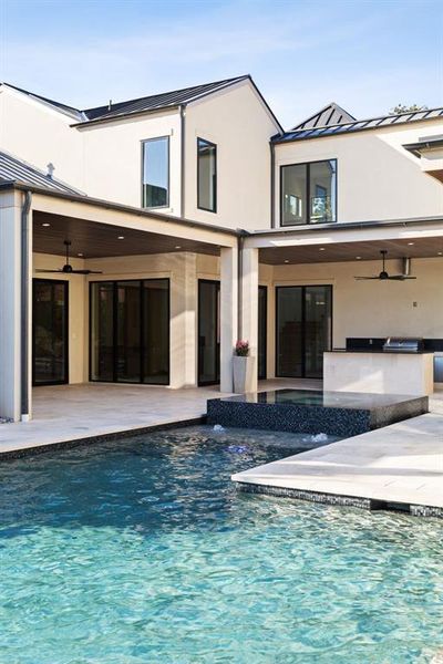 Back of property featuring a ceiling fan, a patio, a standing seam roof, and stucco siding Back of property featuring a ceiling fan, a patio, a standing seam roof, and stucco siding