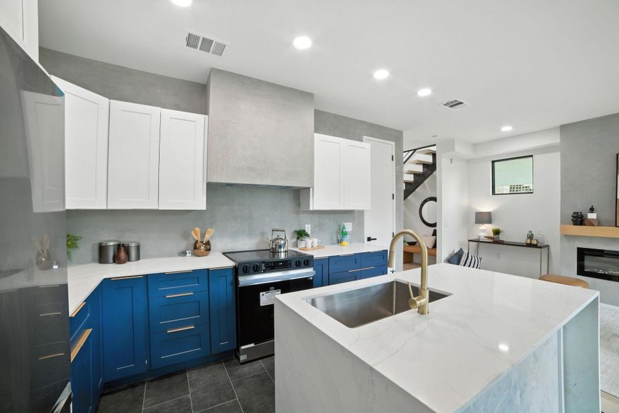 Kitchen with blue cabinetry, black electric range oven, refrigerator, recessed lighting, and white cabinetry Kitchen with blue cabinetry, black electric range oven, refrigerator, recessed lighting, and white cabinetry