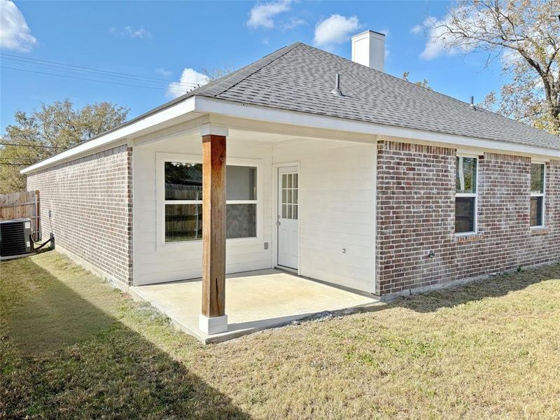 Back of house featuring a patio, brick siding, and a yard