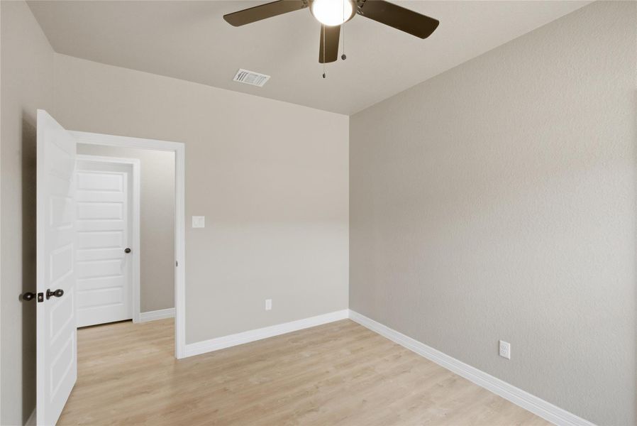 Empty room with light wood-type flooring and a ceiling fan
