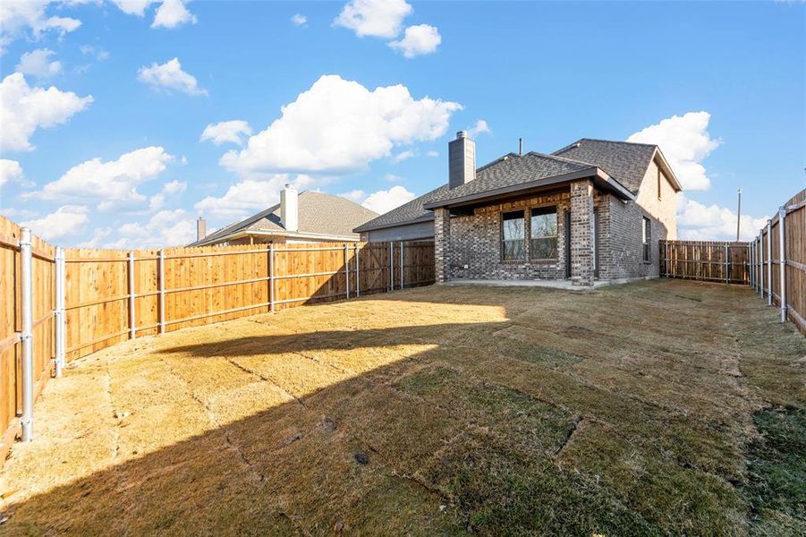 Rear view of house featuring a lawn and a patio area