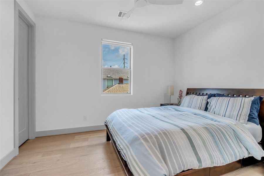 Secondary bedroom on the second floor offers a versatile space that can be personalized to fit your needs, with a window overlooking the neighborhood and bringing in natural light.