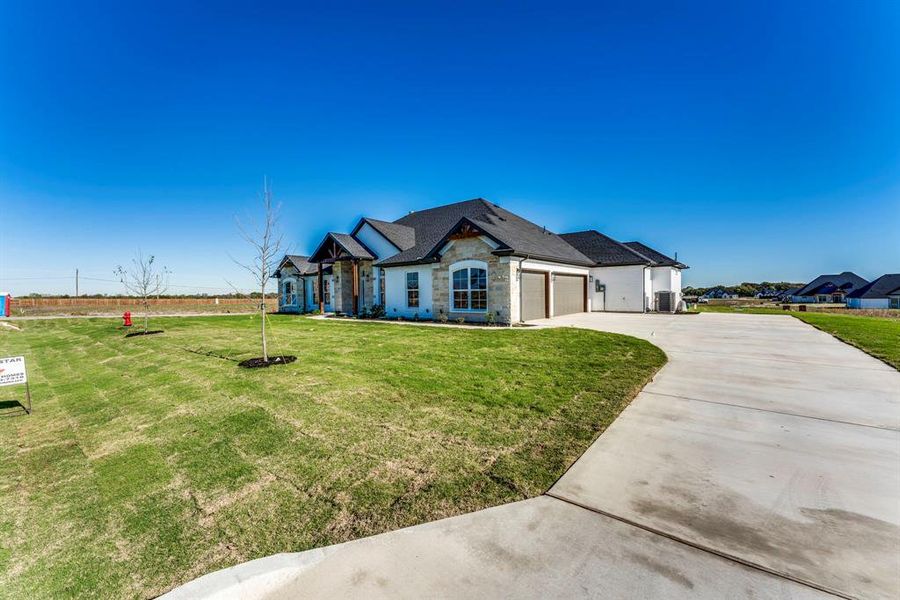 View of front of house with a garage and a front yard