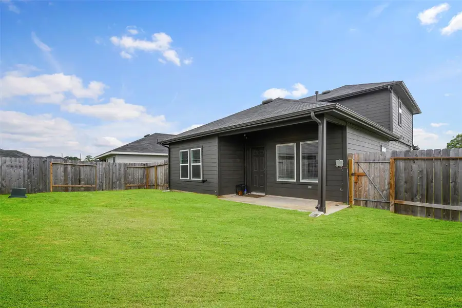 Covered patio overlooking a spacious backyard. Covered patio overlooking a spacious backyard.