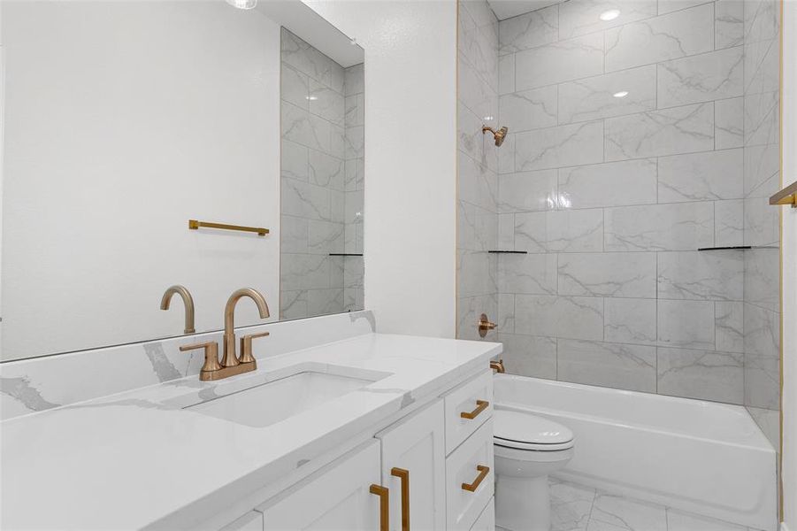 Bathroom with vanity, bathing tub / shower combination, and light marble finish floors