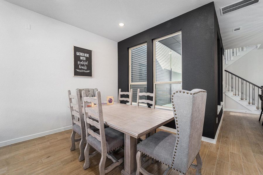 Dining nook with accent wall, artisan lighting, and easy kitchen access.