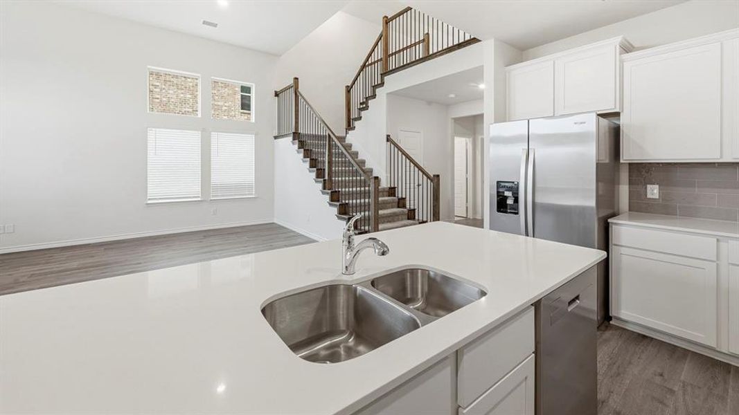 Kitchen island with a dual basin stainless steel sink and quartz countertop