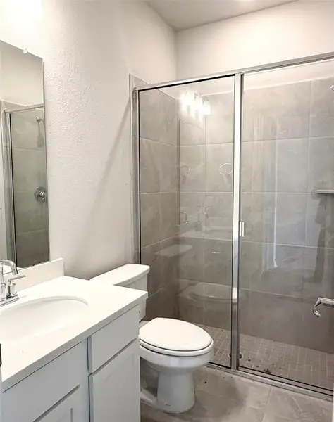 Full bathroom with vanity, a stall shower, and a textured wall Full bathroom with vanity, a stall shower, and a textured wall