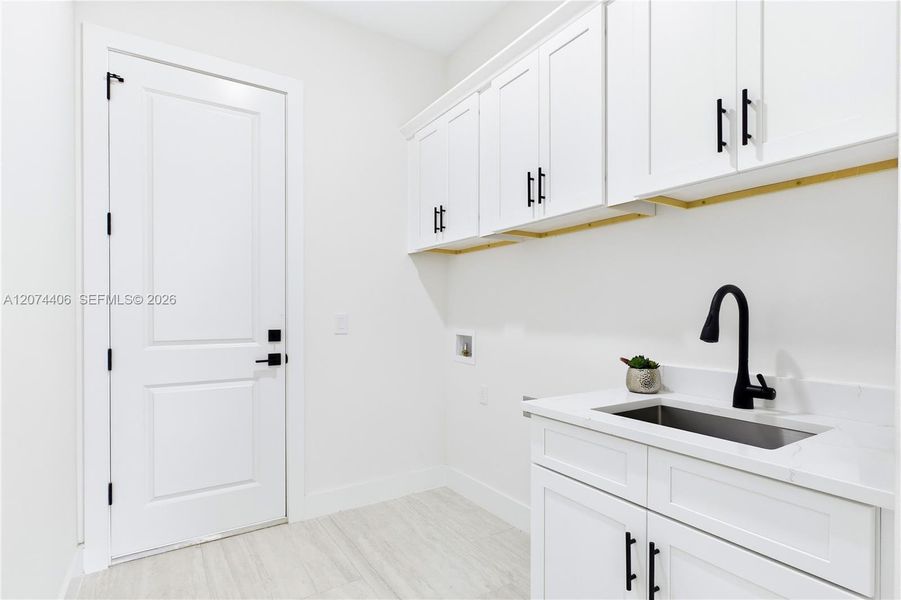 FUNCTIONAL LAUNDRY ROOM combines style & convenience w/ QUARTZ countertops, utility sink & abundant built-in cabinetry for effortless organization! FUNCTIONAL LAUNDRY ROOM combines style & convenience w/ QUARTZ countertops, utility sink & abundant built-in cabinetry for effortless organization!