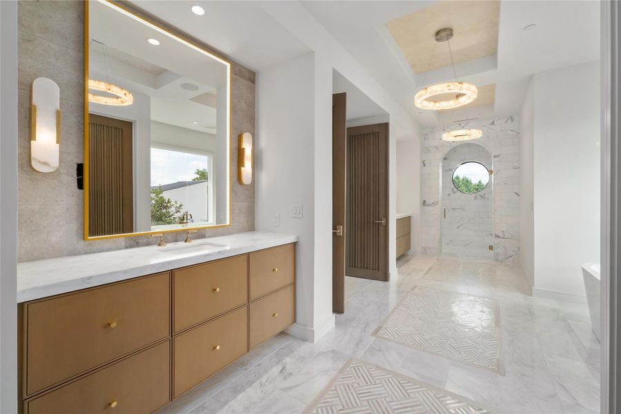 Primary Bath of white marble, framed mirrors with adjustable lighting and soaking tub