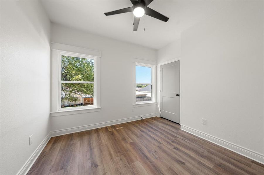 Empty room featuring wood finished floors and a ceiling fan Empty room featuring wood finished floors and a ceiling fan