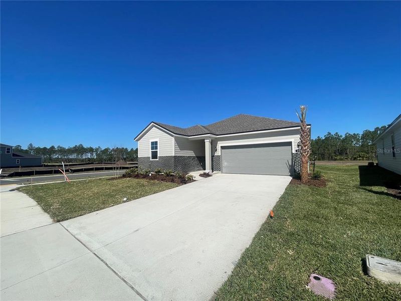 Front exterior of a new home in Magnolia Series at Seminole Palms, Palm Coast, FL, highlighting curb appeal (Image 20). Front exterior of a new home in Magnolia Series at Seminole Palms, Palm Coast, FL, highlighting curb appeal (Image 20).