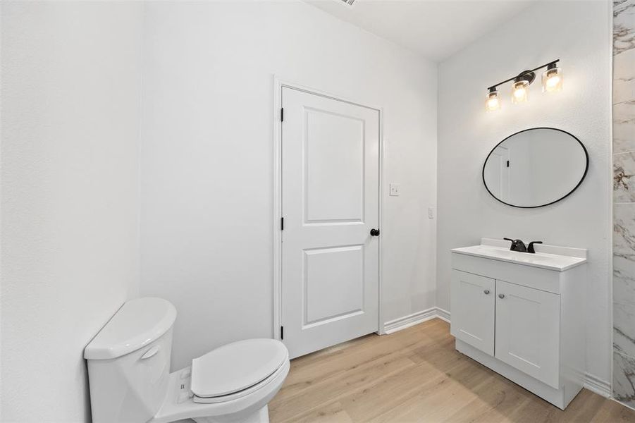 Half bathroom with vanity and light wood-type flooring
