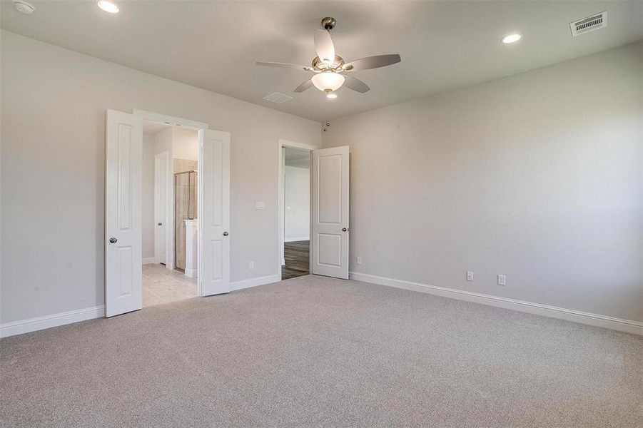 Unfurnished bedroom featuring ceiling fan and light carpet