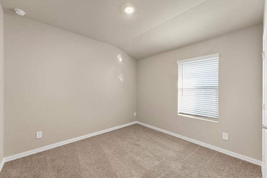 Empty room with carpet and vaulted ceiling Empty room with carpet and vaulted ceiling