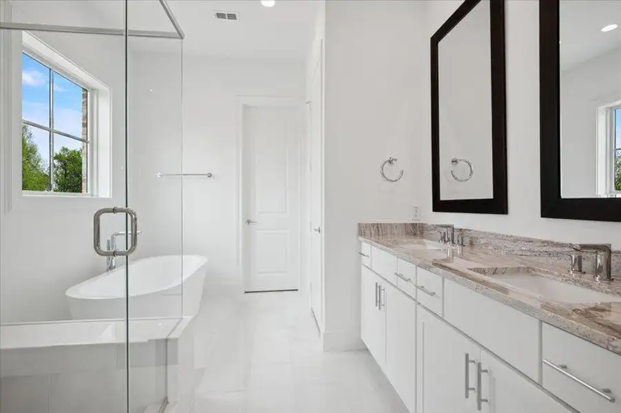 Bathroom with double vanity, a soaking tub, and a shower stall