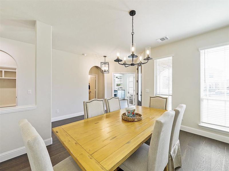 Dining room with a notable chandelier and dark hardwood / wood-style floors