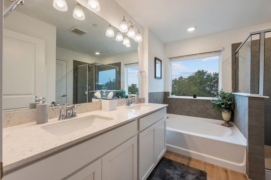 Dual vanity with pristine countertops and a generous soaking tub create a luxurious bathing experience. Dual vanity with pristine countertops and a generous soaking tub create a luxurious bathing experience.