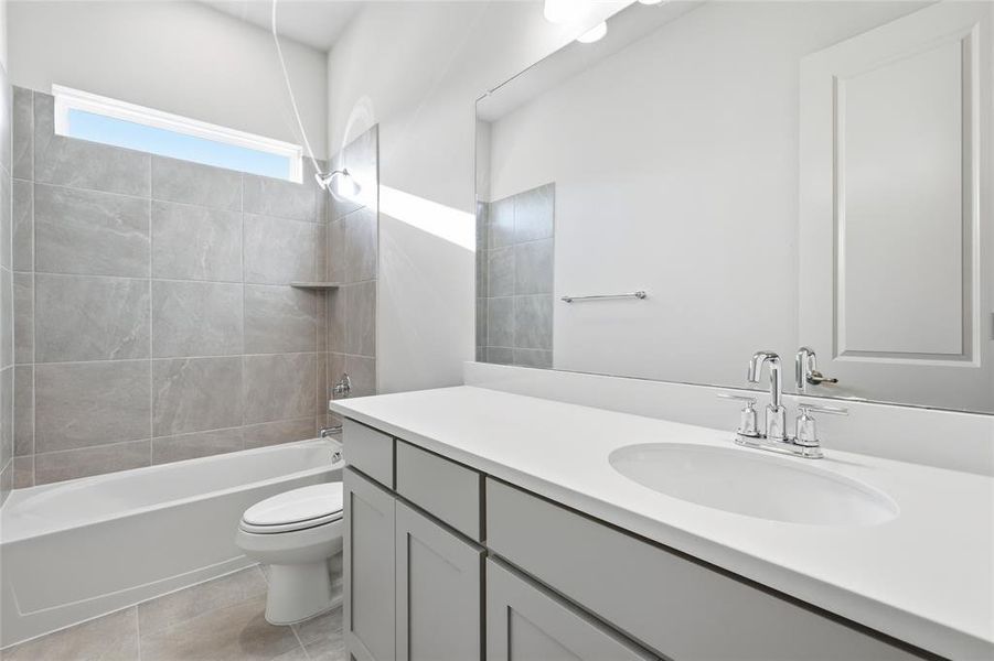 Full bath with shower / bath combination, vanity, and light tile patterned floors Full bath with shower / bath combination, vanity, and light tile patterned floors