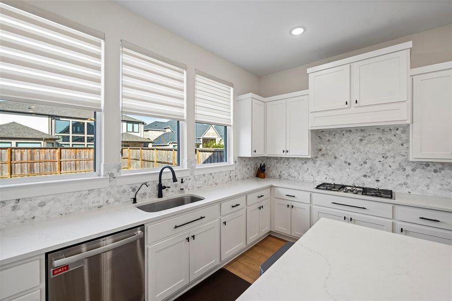 Another view of the kitchen, including the Calcutta Lavasa quartz countertops, Sublimity Daphne White mosaic tile backsplash and Kent Moore Groveland MDF Alabaster cabinetry