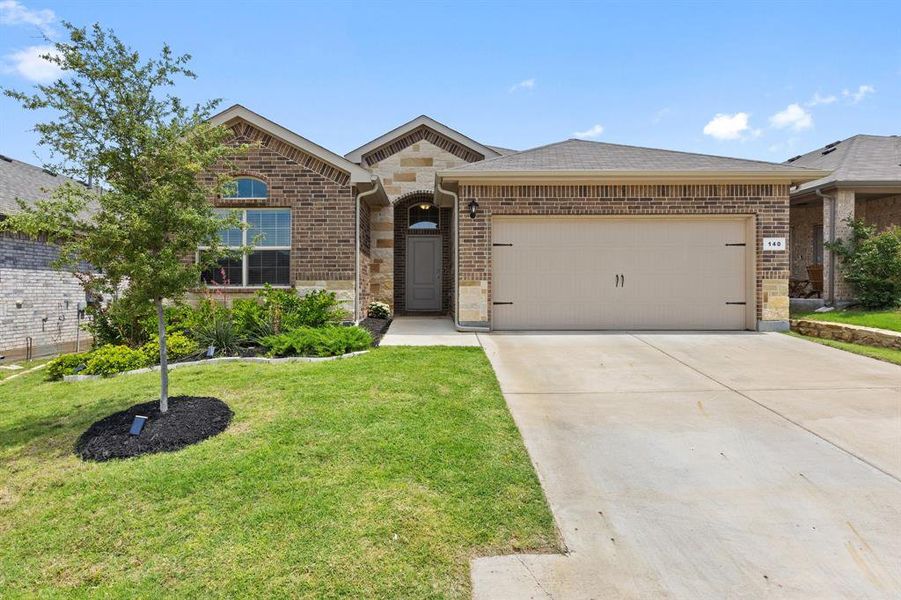 View of front of house featuring brick siding, a front landscaped lawn, 2-garage, concrete driveway, and stone detailing View of front of house featuring brick siding, a front landscaped lawn, 2-garage, concrete driveway, and stone detailing