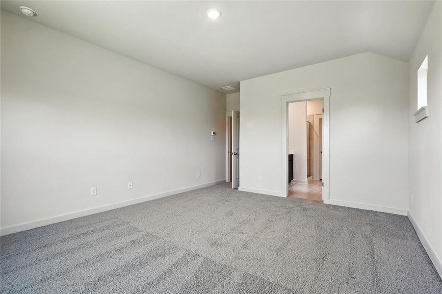 Unfurnished bedroom featuring carpet floors and connected bathroom Unfurnished bedroom featuring carpet floors and connected bathroom