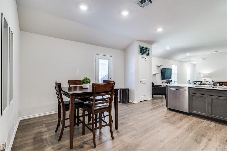 Dining space with light wood-style floors, recessed lighting, and visible vents