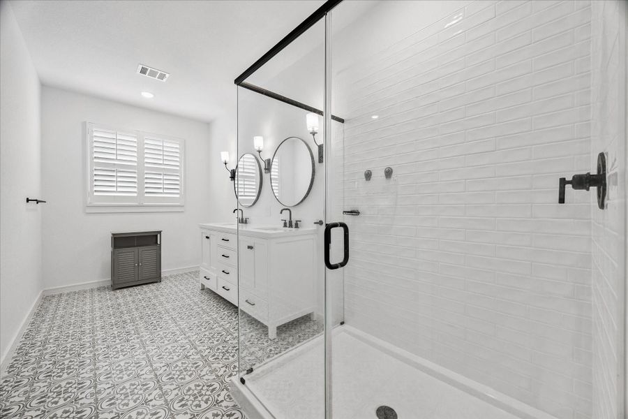 Large frameless glass shower with floor-to-ceiling subway tile and matte black hardware creates a polished custom-home feel.