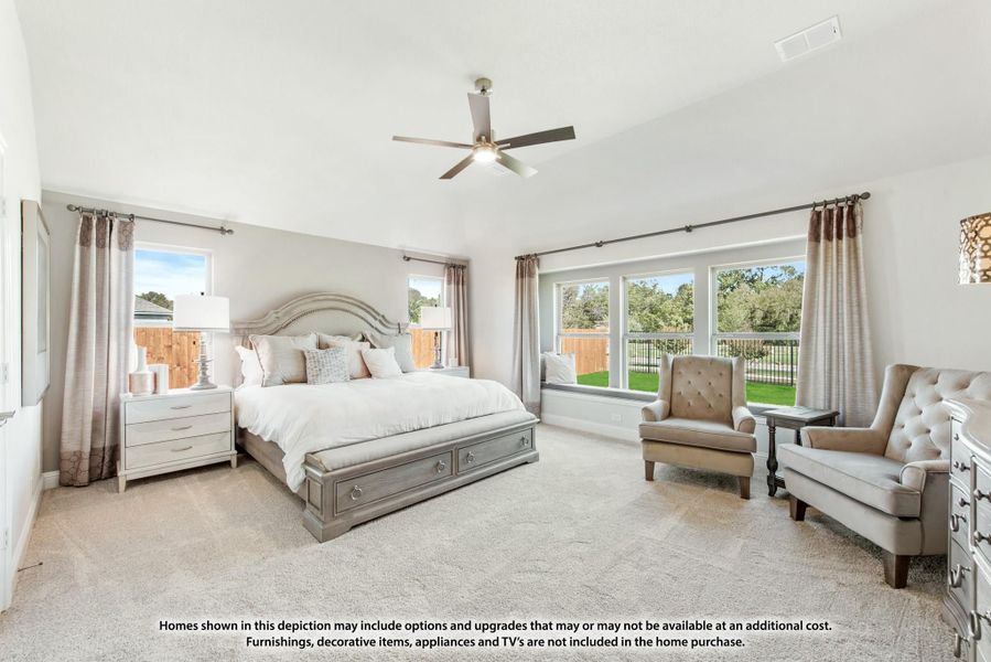 Spacious master bedroom with vaulted ceiling, ceiling fan, window seat, and neutral carpet flooring Spacious master bedroom with vaulted ceiling, ceiling fan, window seat, and neutral carpet flooring