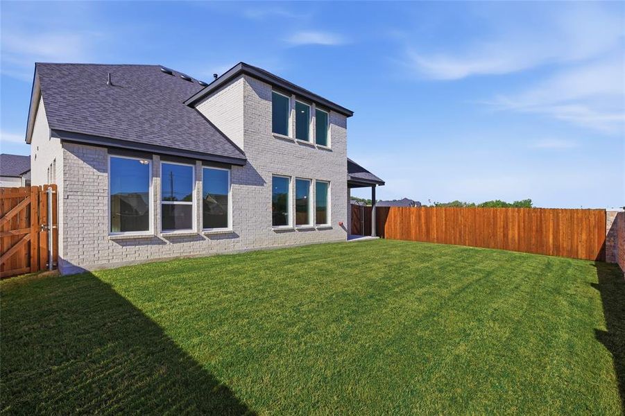 Back of property featuring brick siding, a fenced backyard, roof with shingles, a gate, and a patio Back of property featuring brick siding, a fenced backyard, roof with shingles, a gate, and a patio