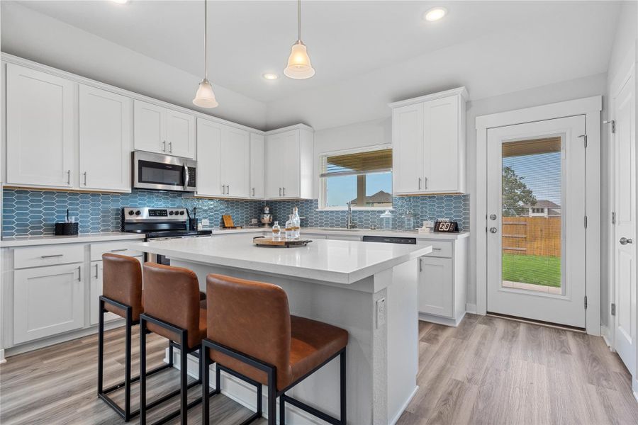 Kitchen featuring appliances with stainless steel finishes, a breakfast bar area, light countertops, recessed lighting, and a sink Kitchen featuring appliances with stainless steel finishes, a breakfast bar area, light countertops, recessed lighting, and a sink