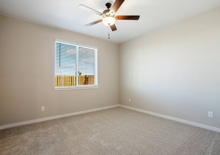 The master bedroom is spacious and has a ceiling fan.