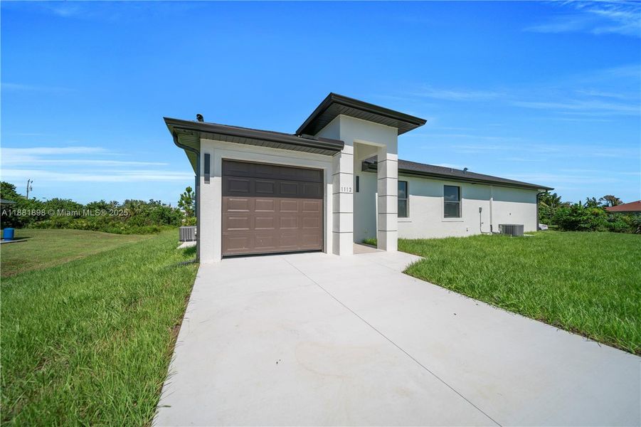 Front exterior of a new home in , Lehigh Acres, FL, highlighting curb appeal (Image 1).