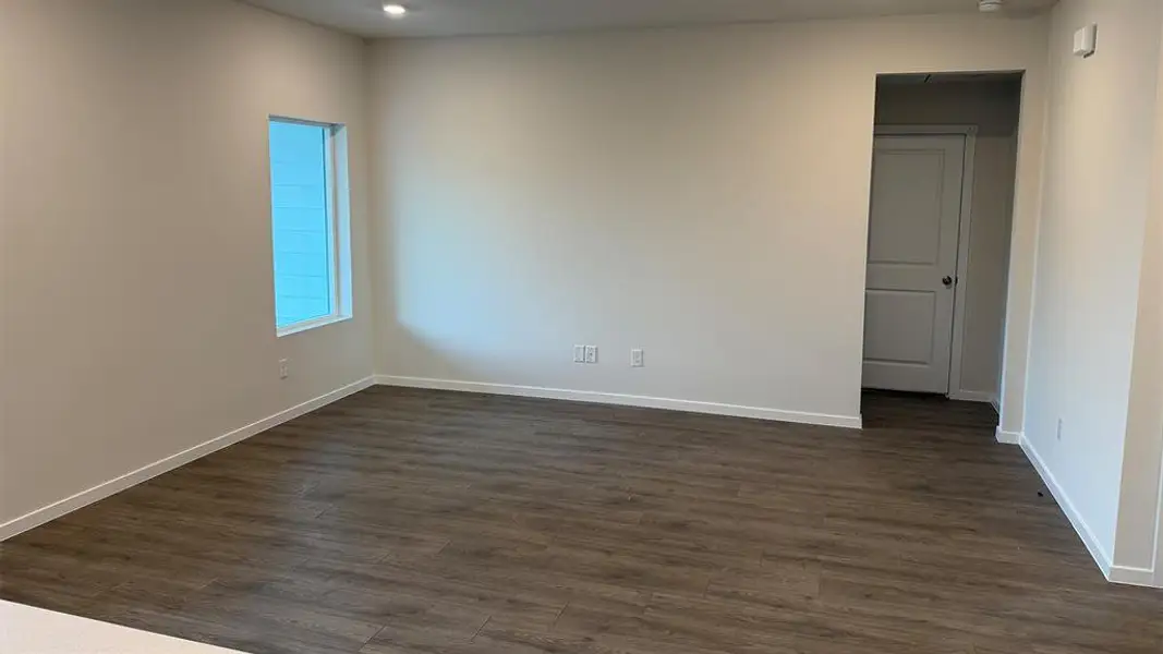 Empty room featuring dark wood-style floors and baseboards
