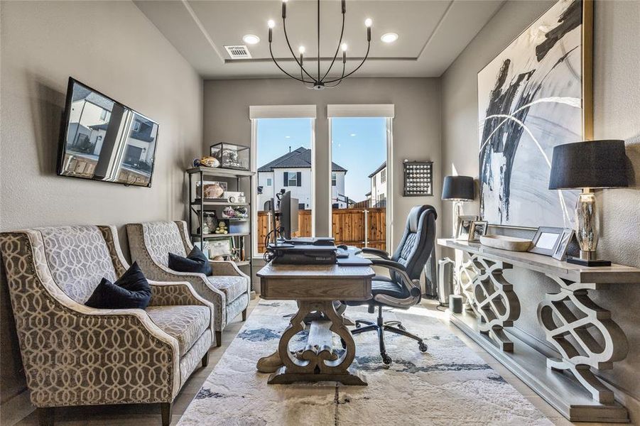 The office has large windows, custom lighting and ceiling treatment