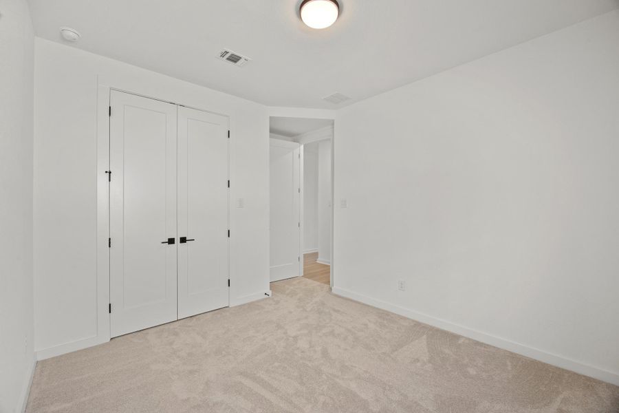 Unfurnished bedroom with light carpet and a closet