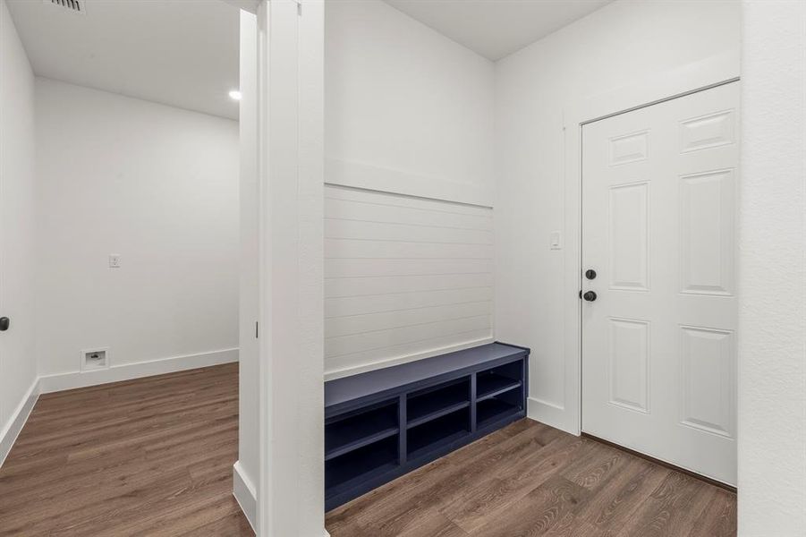Mudroom featuring dark wood-style flooring and baseboards