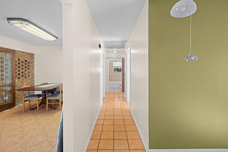 Hallway with light tile patterned floors and baseboards