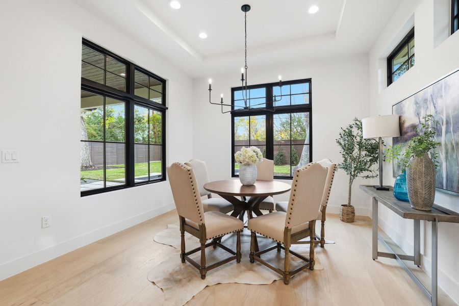 Dining space featuring light wood finished floors, plenty of natural light, recessed lighting, and a chandelier