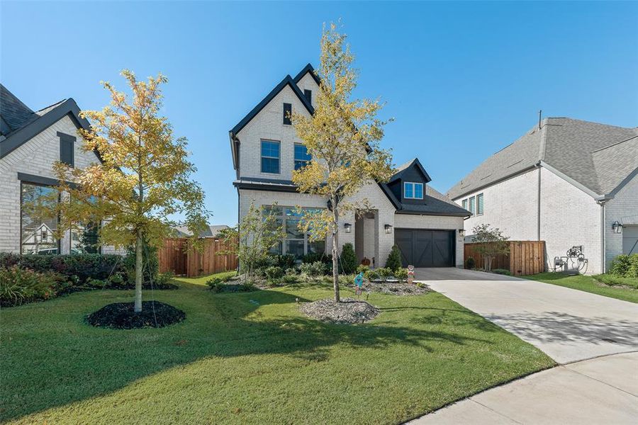View of front of home with concrete driveway, a garage, and brick siding