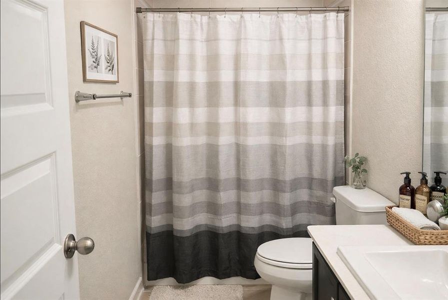 Bathroom with a textured wall, a shower with curtain, and vanity