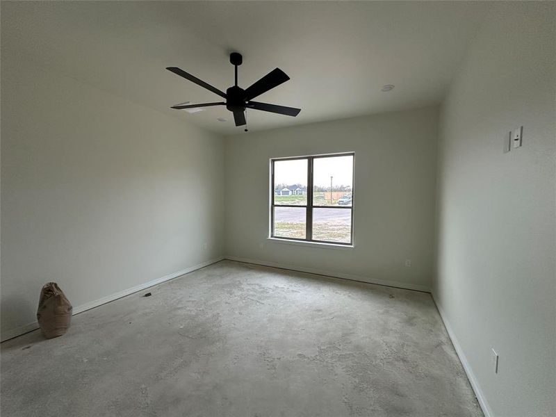 Empty room with unfinished concrete floors and ceiling fan
