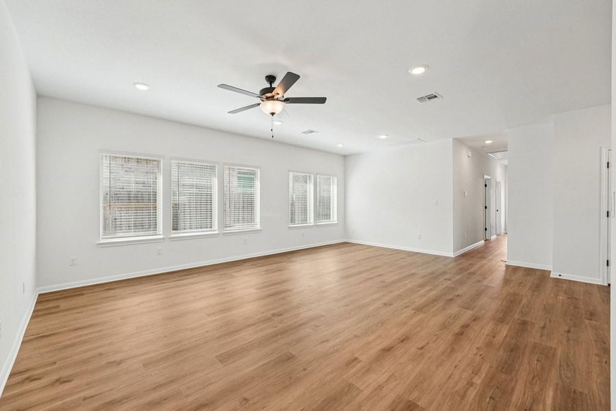 A spacious room features plank flooring and a ceiling fan, offering a comfortable and open atmosphere. A spacious room features plank flooring and a ceiling fan, offering a comfortable and open atmosphere.