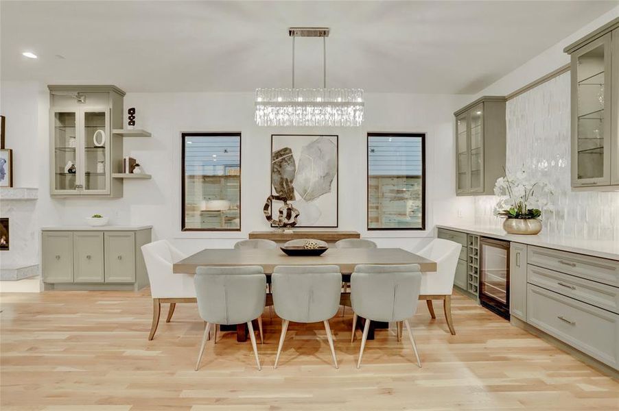 DINING ROOM:  Open concept to both kitchen and living room features a built-in buffet/bar with liquor drawers and beverage center topped with neutral quartz, and backsplash with iridescent picket tile.